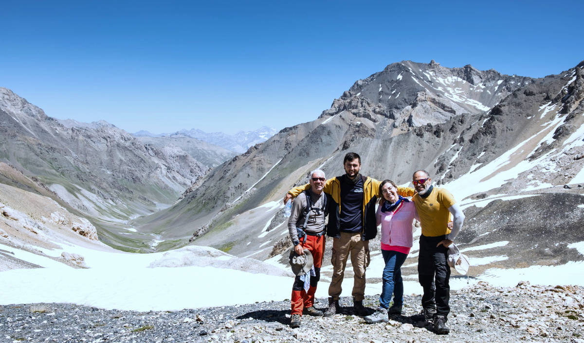 A group of hikers posing with a guide on top of the Kul Pass