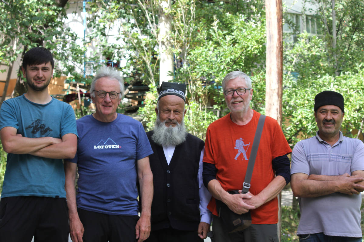 Two tourists and three Tajiks standing next to eachother