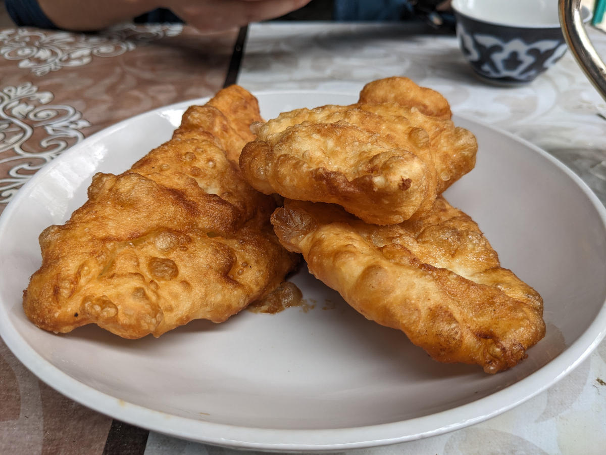Three pieces of piroshki, deep fried dough with a filling of mashed potatoes