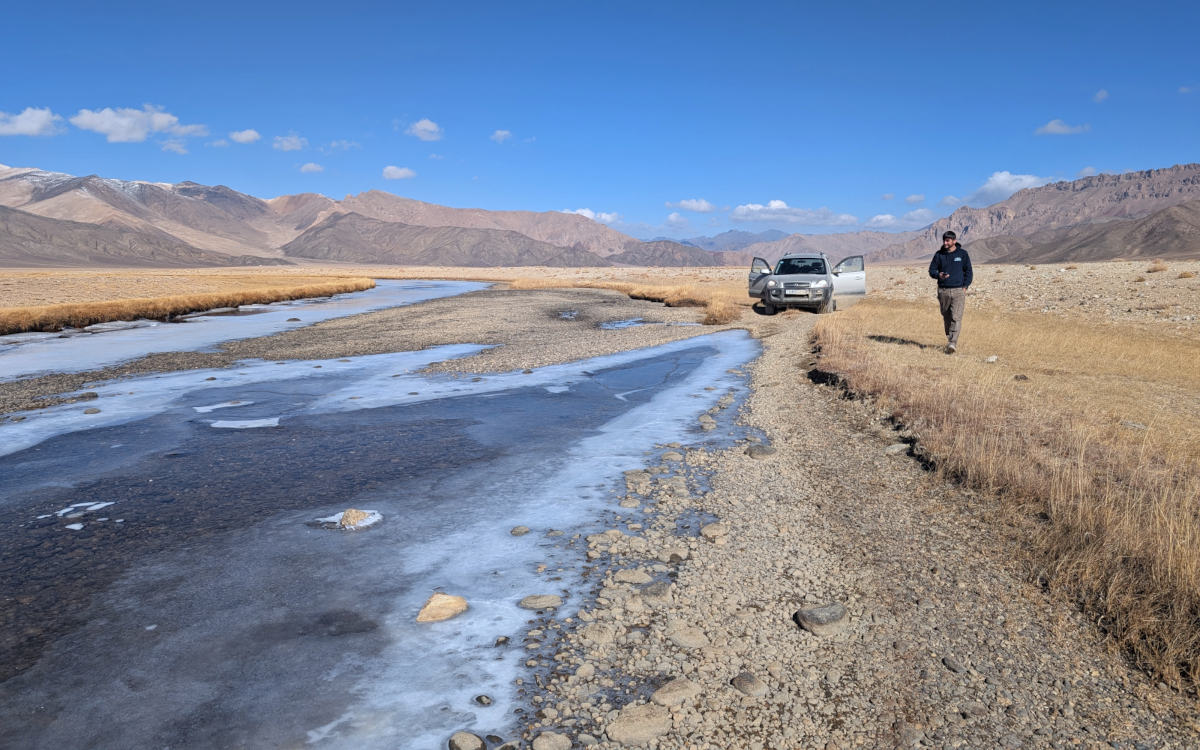 Car crossing a frozen river in the Gurumdy Valley in the east Pamirs
