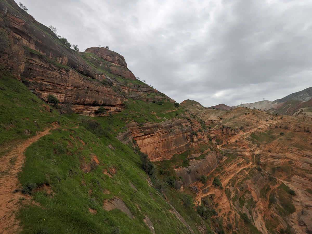 Narrow trail leading across a thick red sandstone formation near Khoja Maston