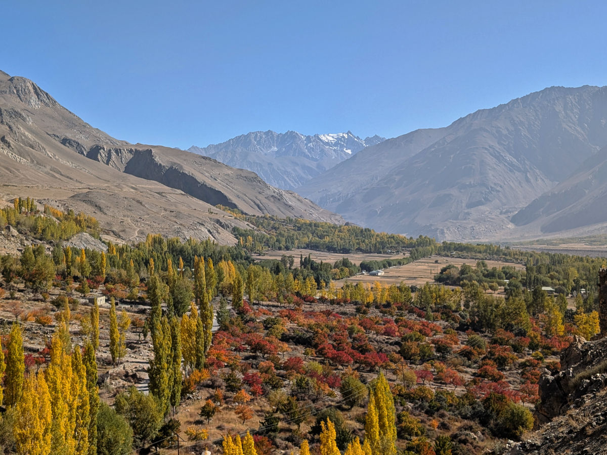 Red, yellow and green trees dotting the Wakhan Valley in the Pamir Mountains in autumn